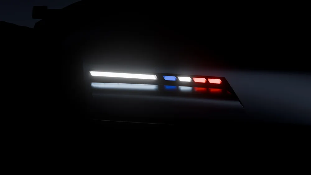 Feux arrière de l’Alpine A310 VISION allumés dans l’obscurité, lames blanches, bleues et rouges.
