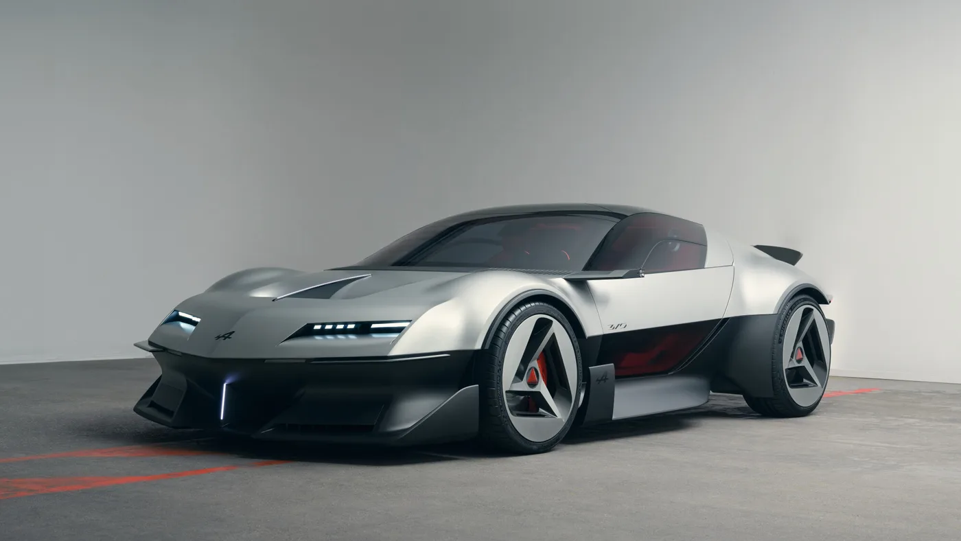 Alpine A310 VISION gris aluminium vue de trois quarts avant dans un studio gris, phares fins allumés et bas de caisse noir.