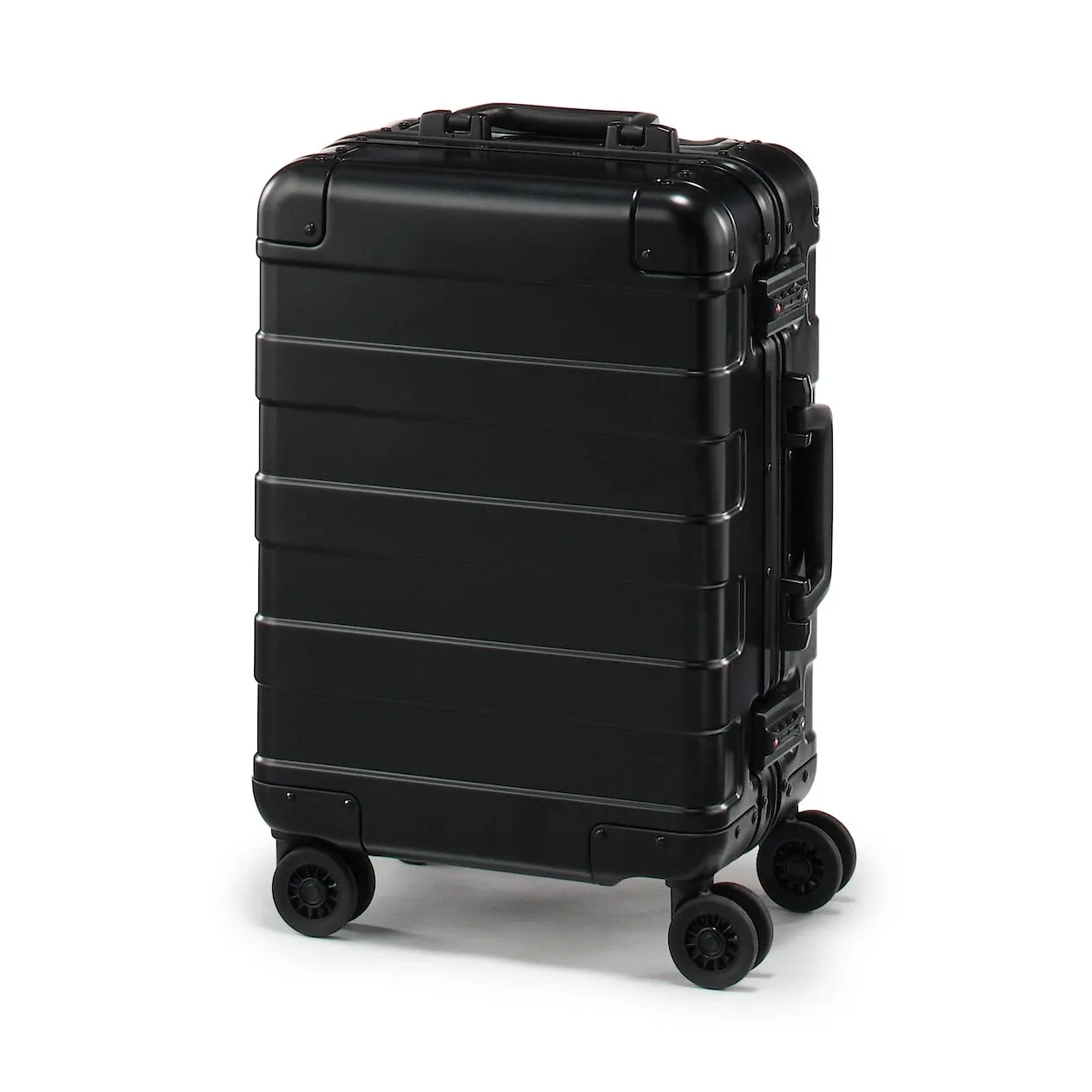 Valise cabine MUJI Labo en aluminium argenté, vue trois-quarts, poignée relevée et roulettes visibles.