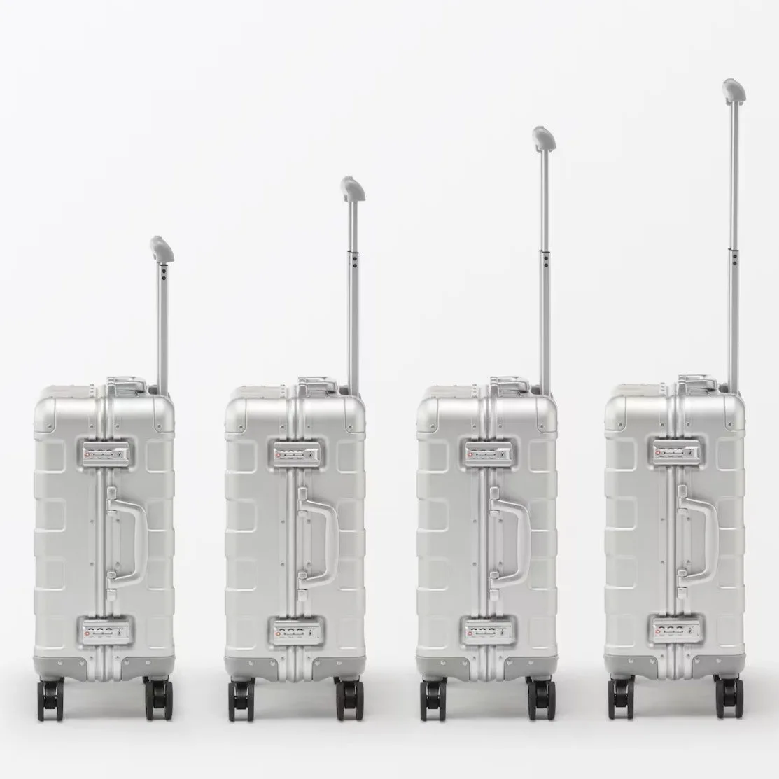 Gros plan sur la coque aluminium rainurée d’une valise MUJI Labo et sur sa poignée télescopique.
