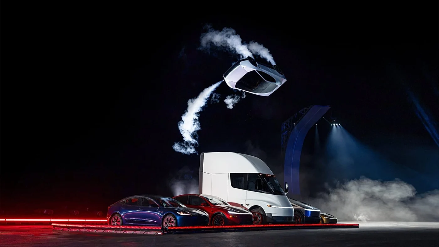 Roadster blanc en l’air au-dessus de plusieurs véhicules Tesla pendant la démonstration nocturne de 2026.